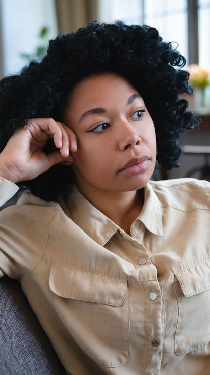 een vrouw staart somber voor zich uit