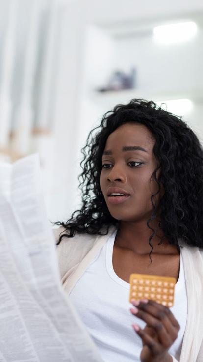 iemand leest de bijsluiter van de pil