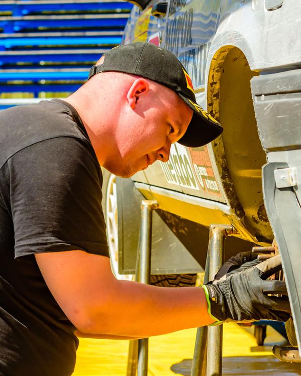 iemand aan het klussen aan een auto in de zon