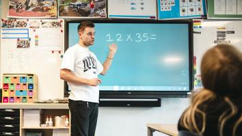 Een leraar legt een rekensom uit die op het bord staat