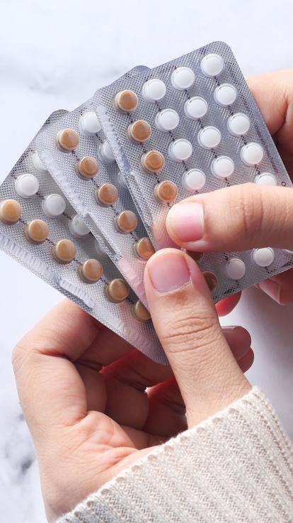 handen houden anticonceptiepillen voor vrouwen vast