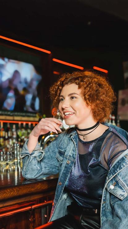 Vrouw zit aan de bar met haar vriendin.