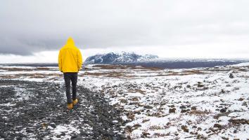 een persoon loopt in een landschap met smeltende sneeuw