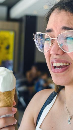 een vrouw krijgt een brain freeze na een ijsje