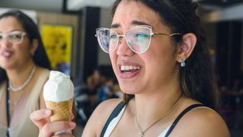 een vrouw krijgt een brain freeze na een ijsje