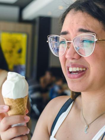 een vrouw krijgt een brain freeze na een ijsje