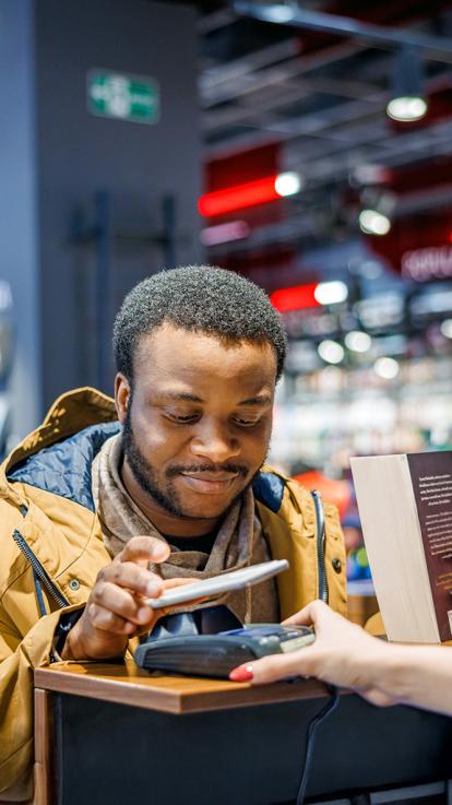 Man is aan het pinnen in een boekenwinkel