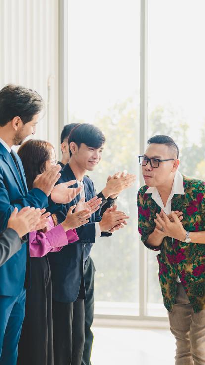 iemand buigt voor mensen die applaudiseren