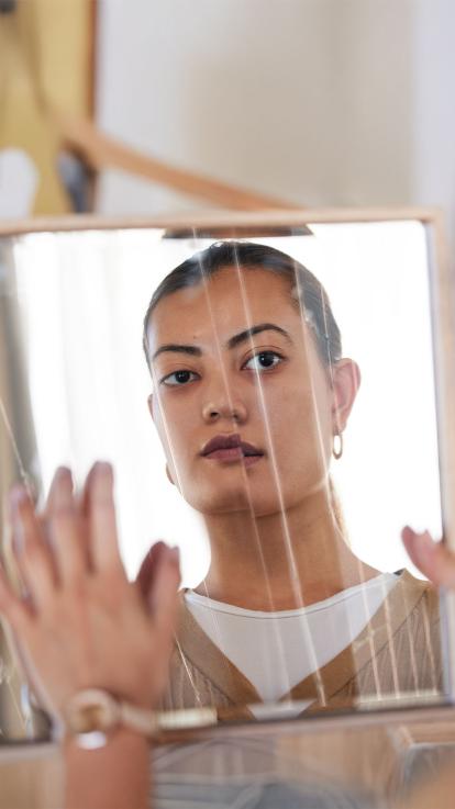 iemand kijkt naar zichzelf in een gebroken spiegel