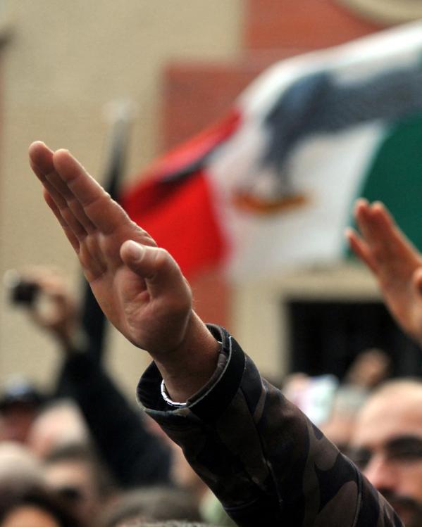 Italianen doen de fascistengroet met fascistische vlaggen op de achtergrond