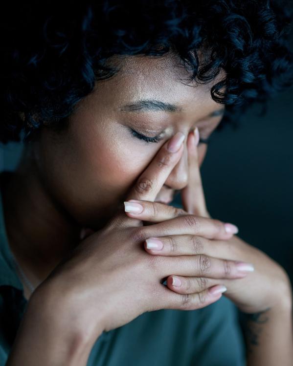 iemand kijkt somber naar beneden met de handen in elkaar