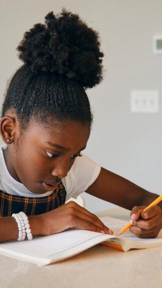 Meisje schrijvend aan tafel