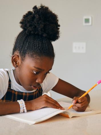 Meisje schrijvend aan tafel