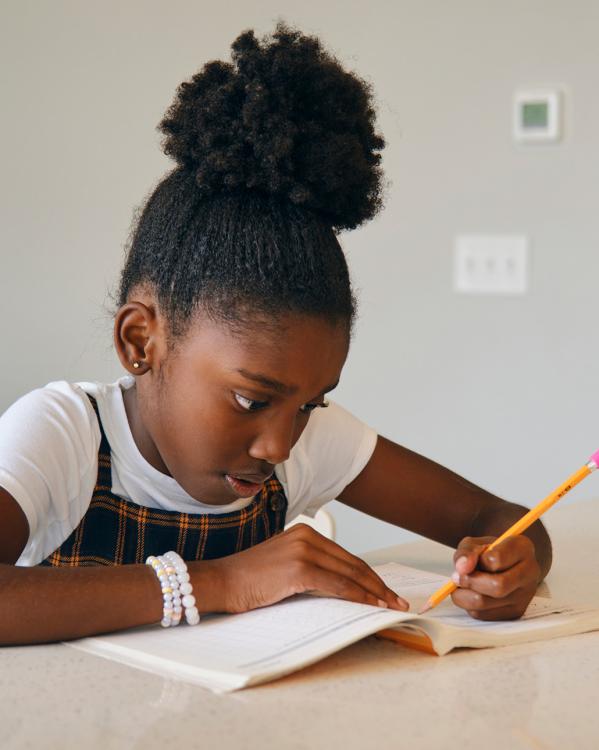 Meisje schrijvend aan tafel