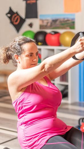 drie mensen volgen een groepsles in een fitnesszaal