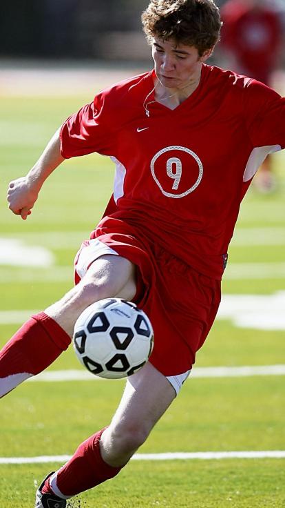 iemand aan het voetballen op een grasveld
