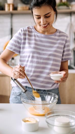 Vrouw voegt suiker toe aan beslag 