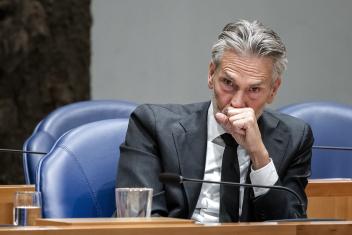 Dick Schoof kijkt gefronst voor zich uit met zijn vuist voor zijn mond