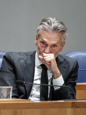 Dick Schoof kijkt gefronst voor zich uit met zijn vuist voor zijn mond