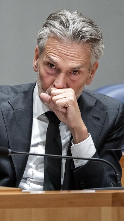 Dick Schoof kijkt gefronst voor zich uit met zijn vuist voor zijn mond