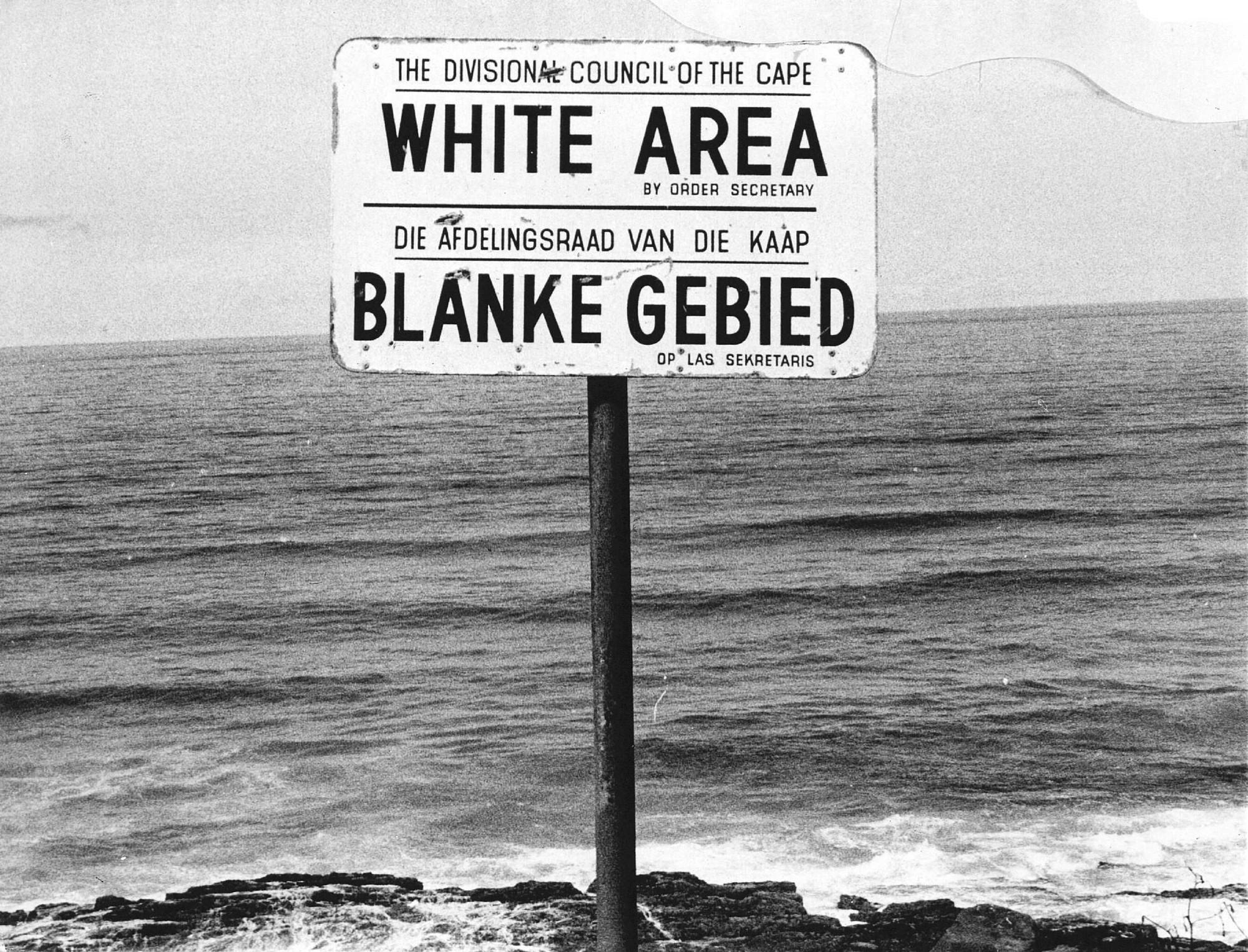 Bord op een strand met de tekst 'White area/Blanke gebied'