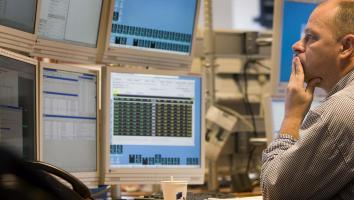 Een man zit vol ongeloof te kijken naar het instorten van de AEX.