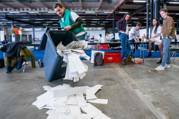 een teller gooit de stembiljetten uit de stemcontainer