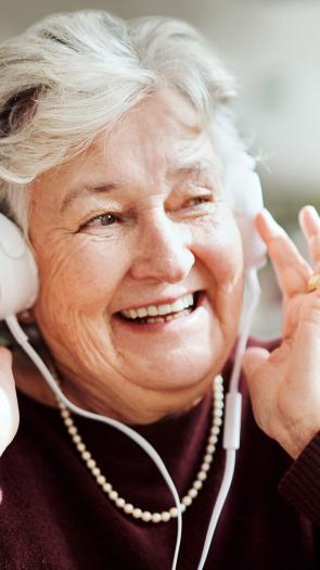 Ouder vrouw luistert naar muziek.
