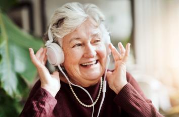 Ouder vrouw luistert naar muziek.