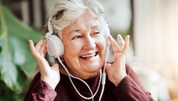 Ouder vrouw luistert naar muziek.