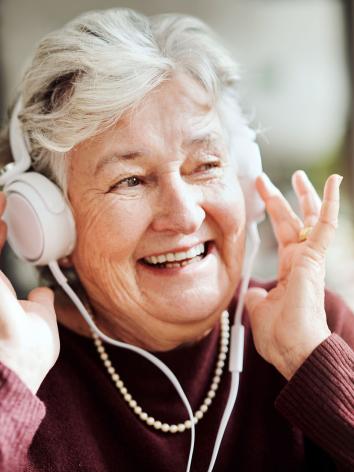 Ouder vrouw luistert naar muziek.