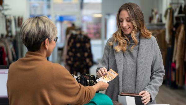 Vrouw betaalt een briefje van 50 euro in een winkel 