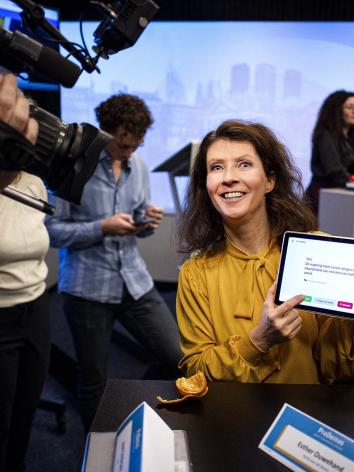 Esther Ouwehand houdt een tablet met een kieswijzer vast.