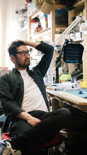 Man zit met hand in zijn haar en kijkt bezorgd op rommelige werkplaats