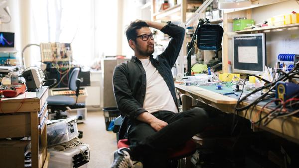 Man zit met hand in zijn haar en kijkt bezorgd op rommelige werkplaats