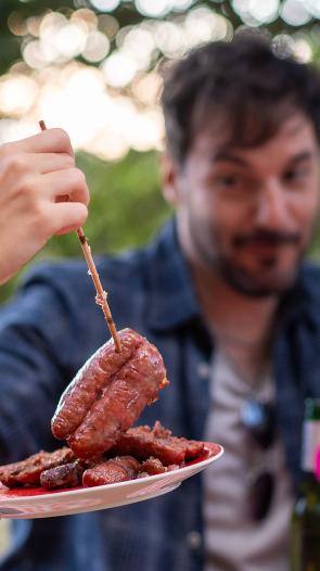 mensen pakken rauw vlees van een bordje voor de bbq