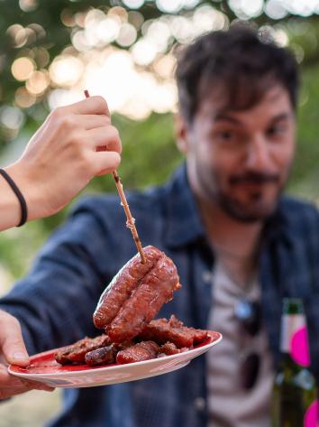 mensen pakken rauw vlees van een bordje voor de bbq