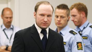 Anders Breivik in pak met agenten om hem heen