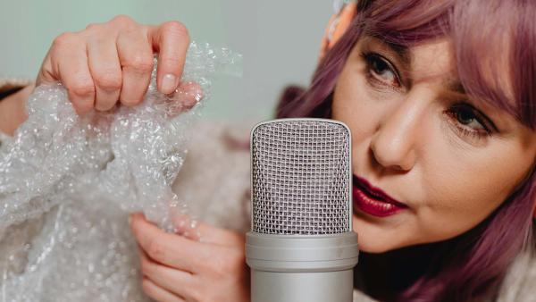 een vrouw knispert met plastic voor een microfoon