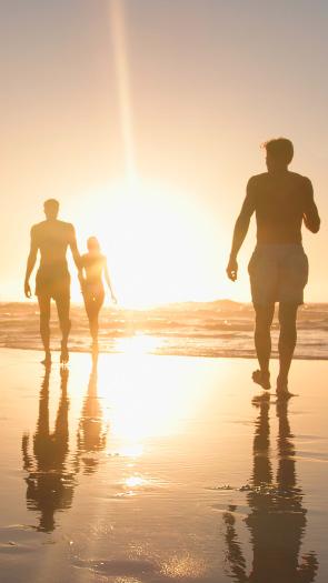 mensen op het strand bij ondergaande zon