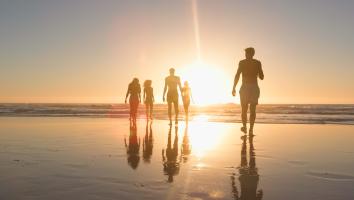 mensen op het strand bij ondergaande zon
