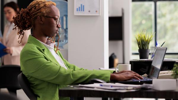 een vrouw zit aan haar bureau
