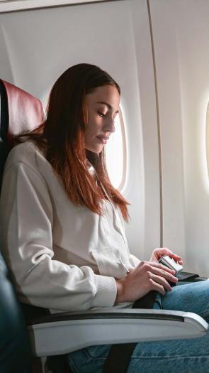 Vrouw doet haar gordel vasti n het vliegtuig.