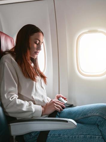 Vrouw doet haar gordel vasti n het vliegtuig.