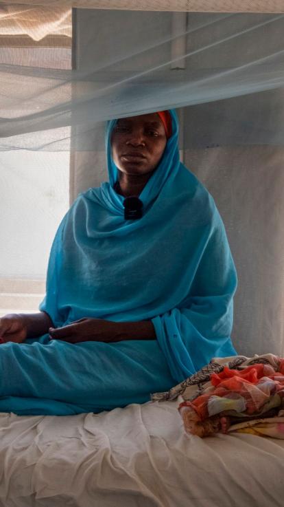 een vrouw zit vermoeid op een bed in een kliniek