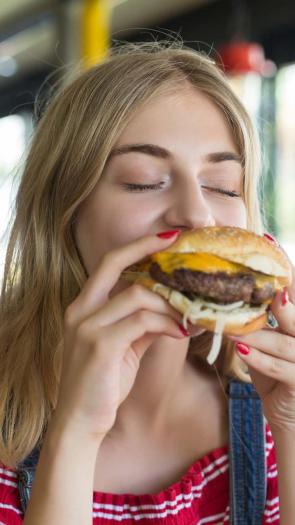 slanke vrouw eet een burger.