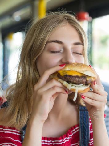 slanke vrouw eet een burger.