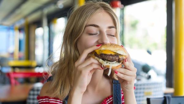slanke vrouw eet een burger.