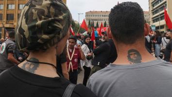 De achterkant van het hoofd van twee mannen met een portret van Che Guevara in hun nek getatoeëerd