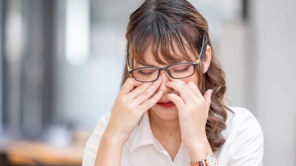 een vrouw wrijft in haar ogen